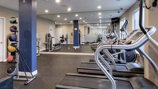 a gym with cardio equipment and weights in a building