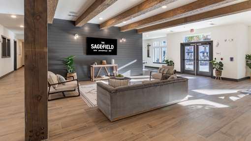 A modern office lobby with a reception desk and seating area.