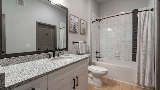 A bathroom with a sink, toilet, and bathtub.