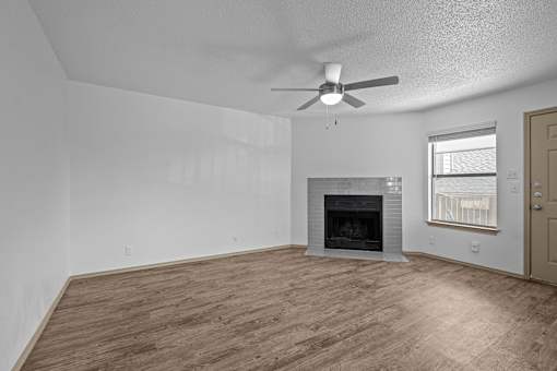 A room with a fireplace and a ceiling fan.