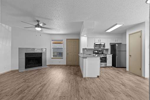 A spacious kitchen with a fireplace and a refrigerator.