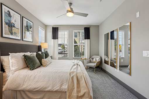 A bedroom with a large bed and a ceiling fan.