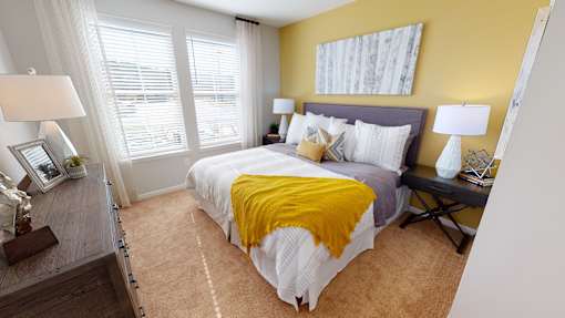 A bedroom with a bed, two lamps, and a window.