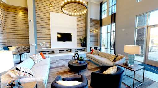 A modern living room with a large couch, a coffee table, and a TV.