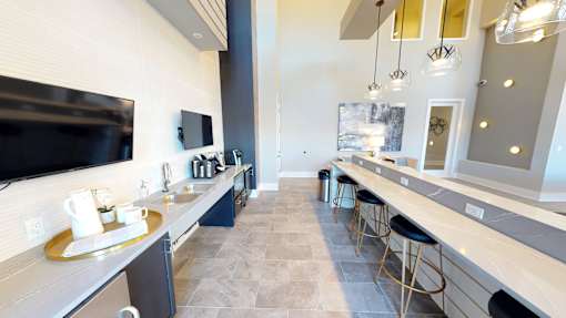A modern kitchen with a long counter and bar stools.