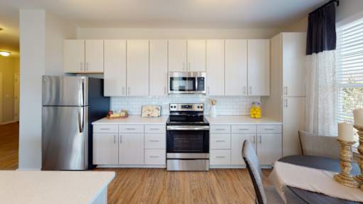 A modern kitchen with white cabinets and stainless steel appliances.