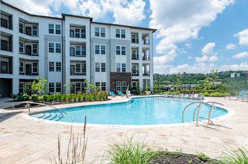 A large white building with a pool in front.