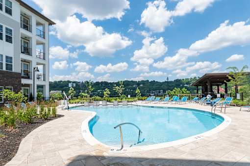 A swimming pool surrounded by a white building and blue sky.