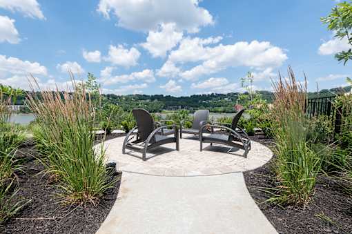 A park with a bench and a table in the middle of a circular walkway.
