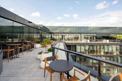 A glass building with a patio area in front.