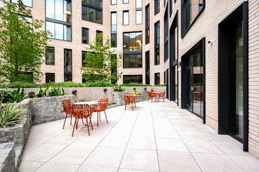 A patio with chairs and a table in front of a building.