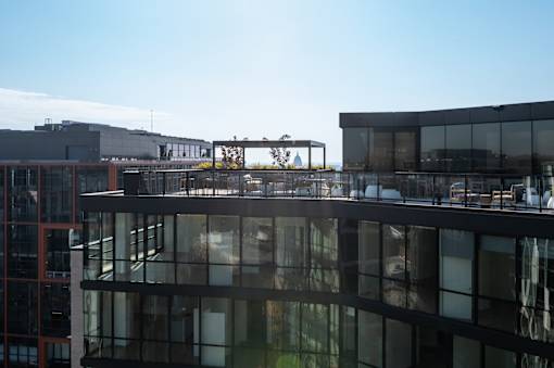 A modern building with glass windows and a metal structure on top.