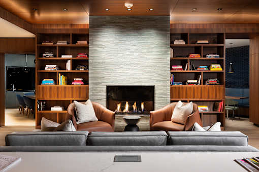 A modern living room with a fireplace and leather chairs.
