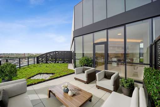 A modern balcony with a glass wall and a wooden coffee table.