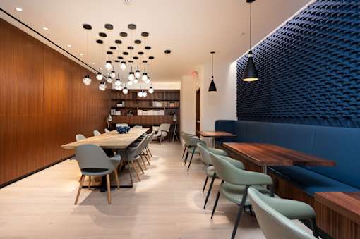 A modern dining area with a long table and chairs.