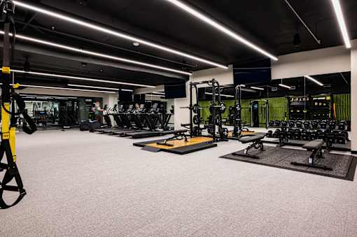 A well-lit gym with various exercise equipment.