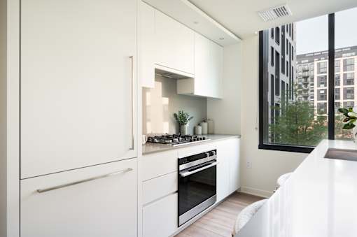 A modern kitchen with white cabinets and appliances.