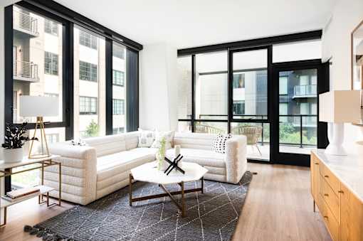 A modern living room with a white sofa and a coffee table.