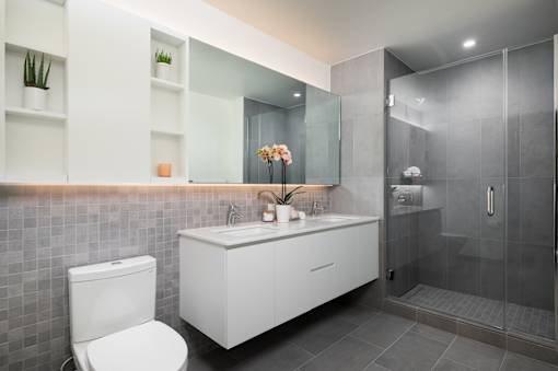 A modern bathroom with a toilet, sink, and shower.