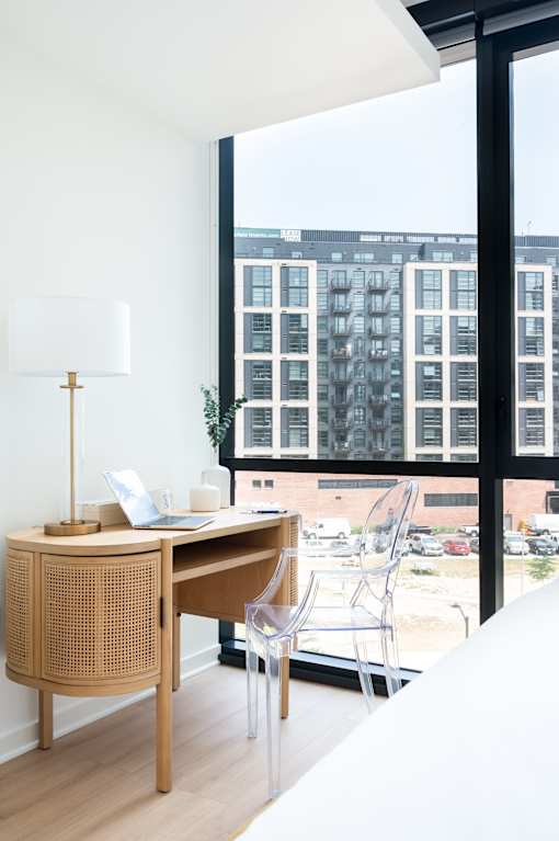A desk with a laptop and a lamp on it.