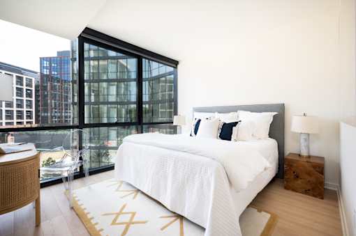 A bedroom with a large bed and a view of the city.