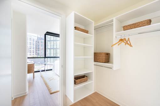A hallway with a white wall and a white door.