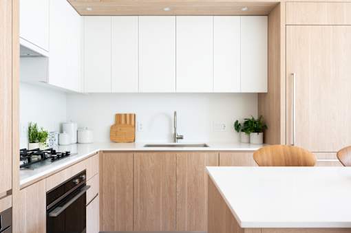 A modern kitchen with wooden cabinets and a white countertop.