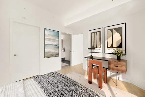 A room with a desk and two framed pictures on the wall.