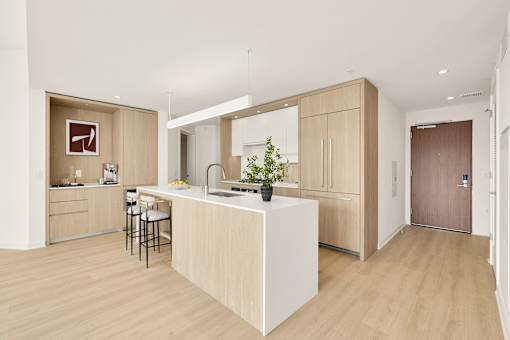 A kitchen with a white island and wooden floors.
