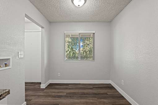 A room with a window and wooden floors.