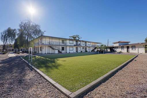 A sunny day at a residential area with a building and a green lawn.