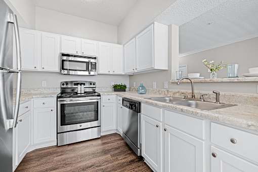 A kitchen with white cabinets and stainless steel appliances.