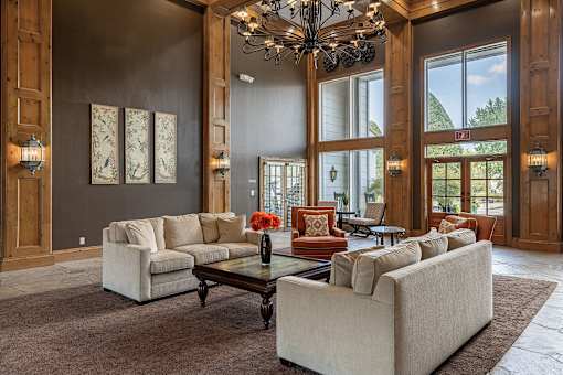 A large room with a chandelier, couches, and a coffee table.