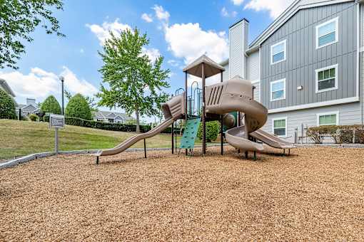 A playground with a slide and a play structure.