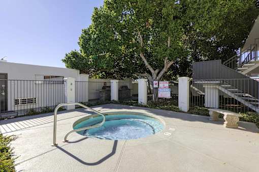 A pool surrounded by a fence and trees.