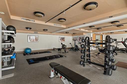 A gym with a variety of equipment including weights and exercise balls.