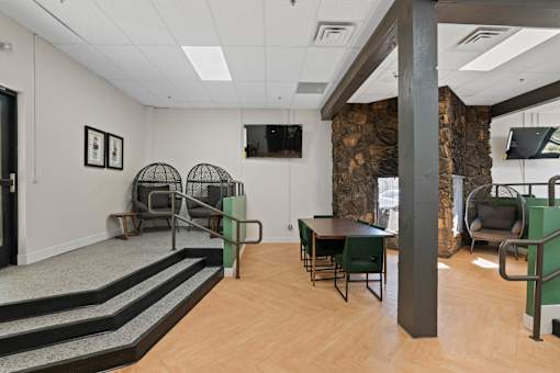 A room with a stone wall and a TV mounted on the wall.