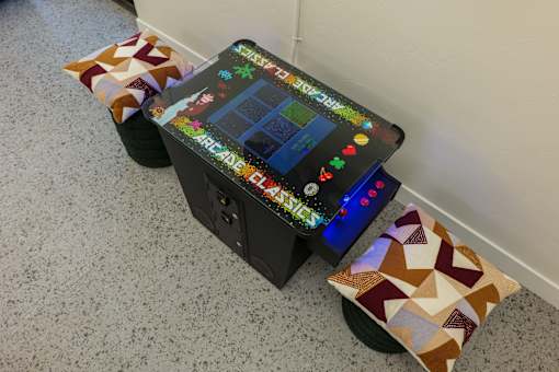 A small arcade machine sits on a carpeted floor.