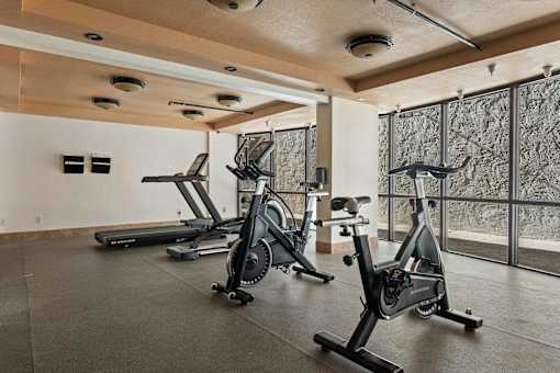 Three exercise bikes are lined up in a room.