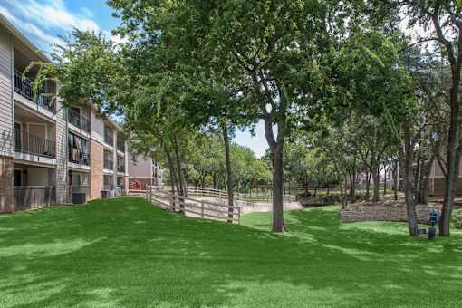 A grassy area in front of apartment buildings.