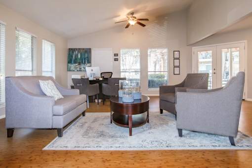 A living room with a grey couch, a coffee table, and a ceiling fan.
