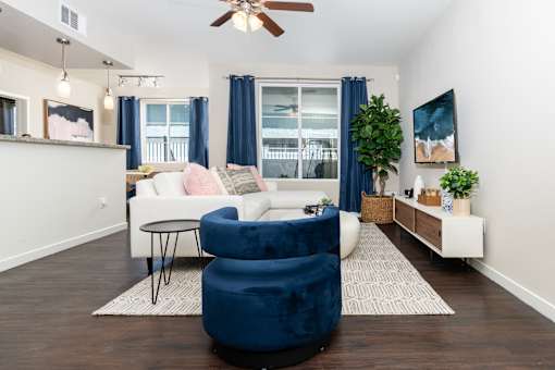 A living room with a white couch and a blue chair.