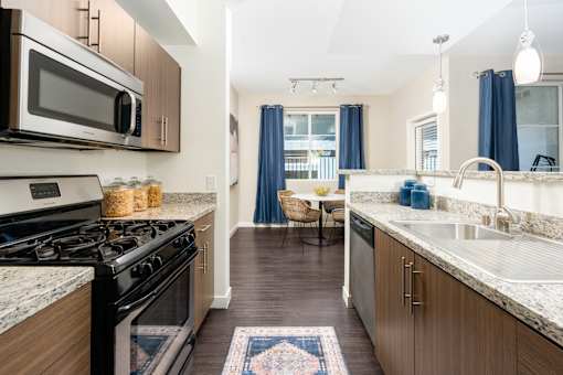 A kitchen with a black stove top oven and a black and white marble counter top.