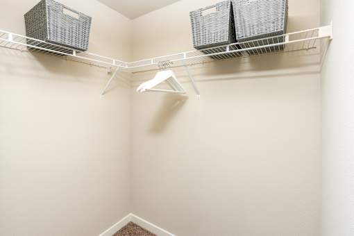 A white closet with a shelf and two air conditioners.