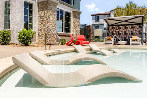 A modern pool with a red sculpture in the middle.