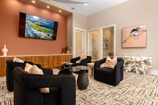 A living room with a large television and comfortable seating.