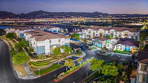 A residential area with houses and streets illuminated at dusk.