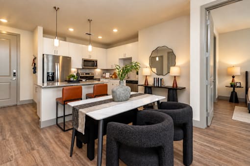 A modern kitchen with a dining table and chairs.