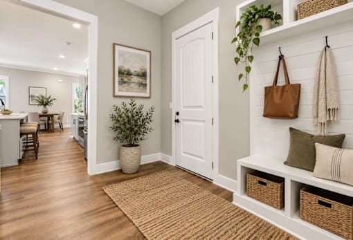 A hallway with a brown rug and a white door.