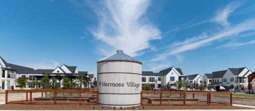 a grain silo sits in front of a row of houses